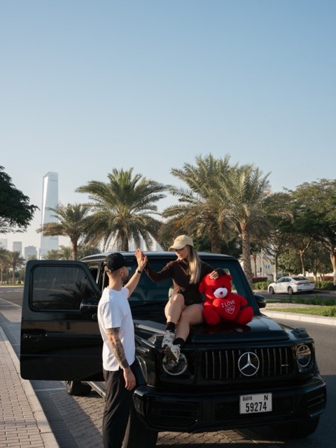 Valentina y Javi chocando la mano junto a su coche