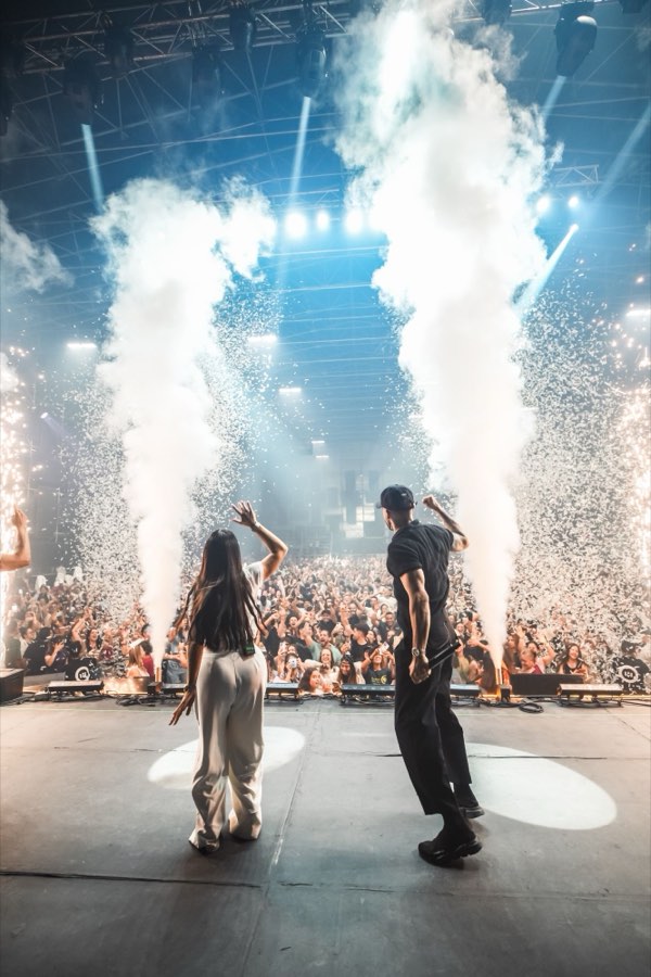 Valentina y Javi en el escenario, de espaldas, ante miles de personas